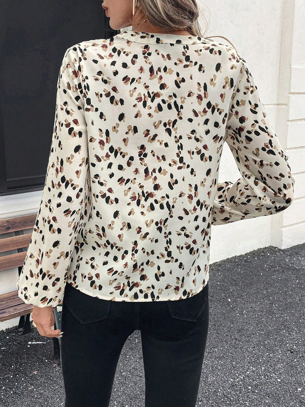 pikywiky long sleeve V-neck blouse featuring a cream base with a multi-colored abstract print, worn from the back.