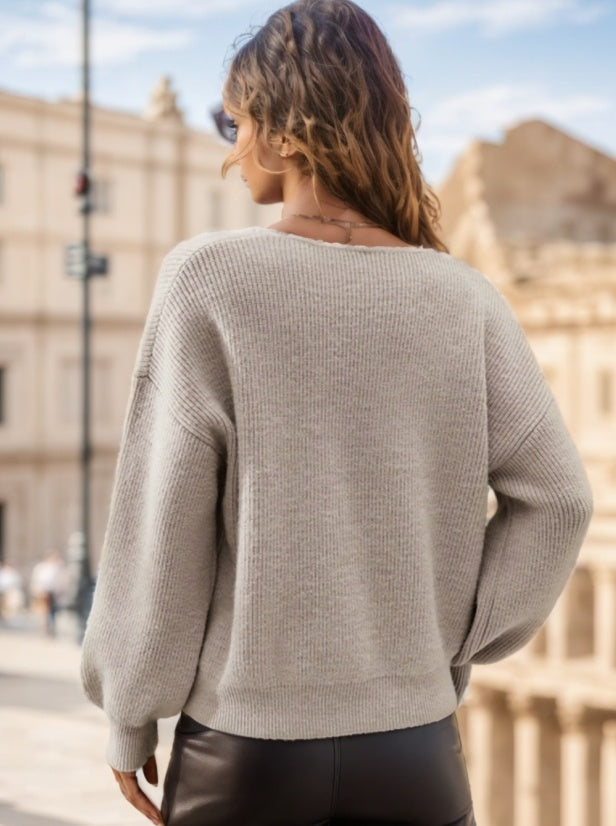 pikywiky beige ribbed knit V-neck sweater with long sleeves worn by a woman in a city setting