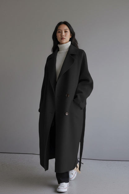pikywiky black cashmere lapel coat worn by a woman over a white turtleneck sweater and sneakers