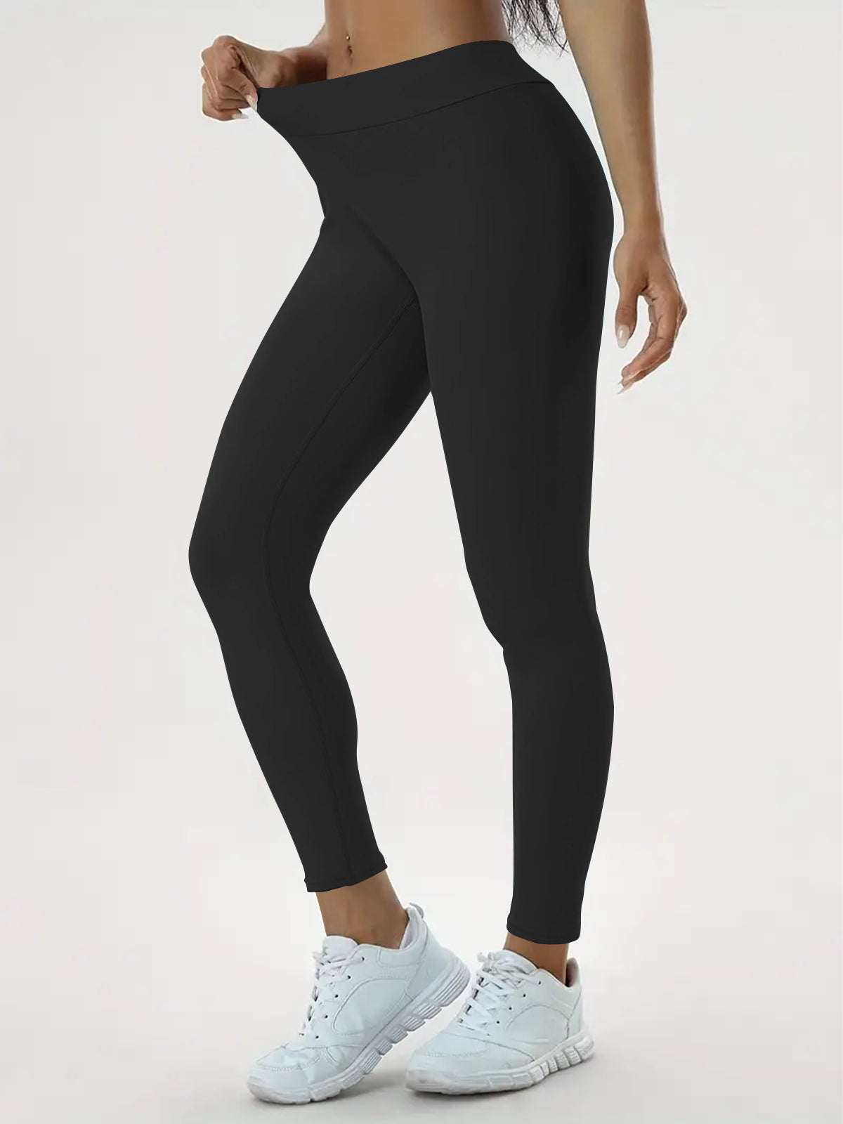pikywiky black high-waisted athletic leggings with ruched back detail worn by a model with white sneakers