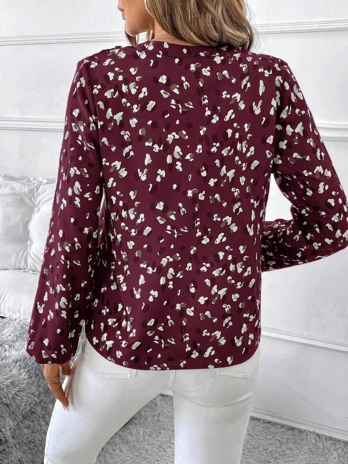 pikywiky long sleeve blouse in burgundy with white and grey abstract print, back view worn with white trousers