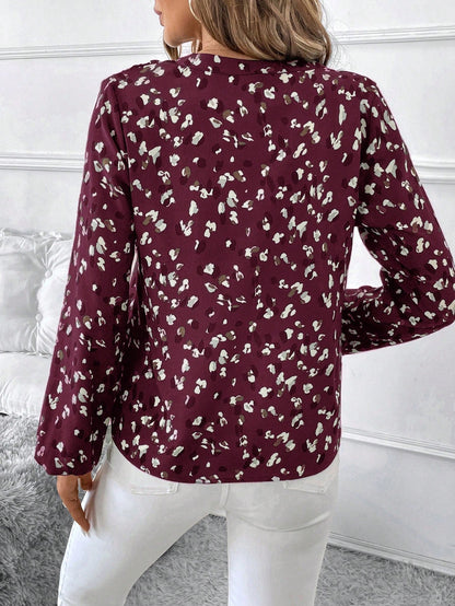 pikywiky long sleeve blouse in burgundy with white and grey abstract print, back view worn with white trousers