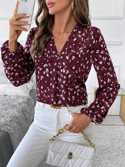 pikywiky burgundy long sleeve V-neck blouse with abstract white print worn by a woman with white jeans and a handbag