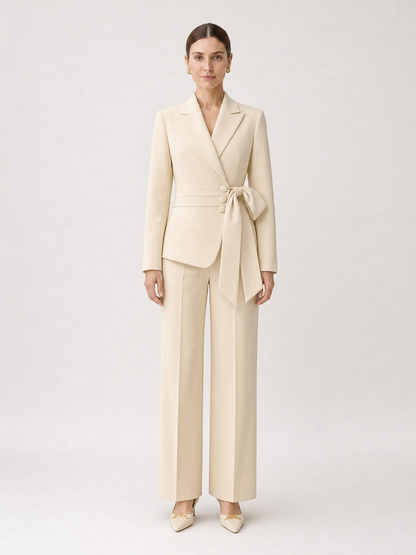 Model wearing a pikywiky cream tailored blazer with a side-tie waist belt and matching wide-leg trousers.