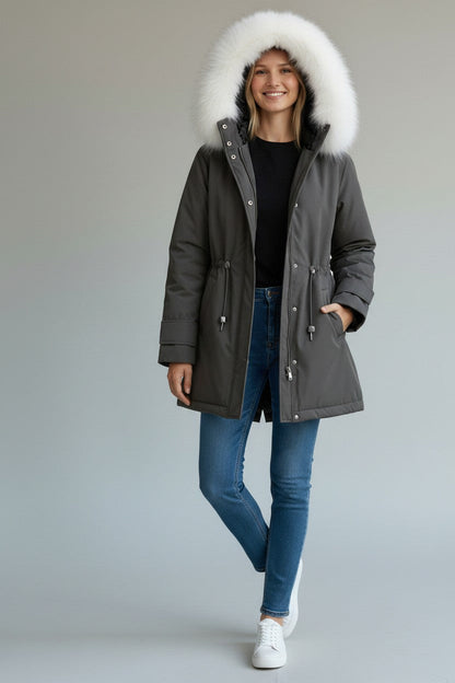pikywiky grey puffer jacket with plush white faux fur hood worn by a smiling woman with blue jeans