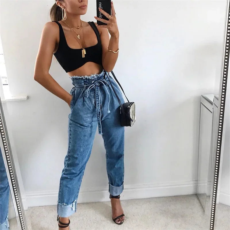 pikywiky high-waisted blue denim jeans with a paperbag waist, tie-belt, and raw frayed hem worn by a woman