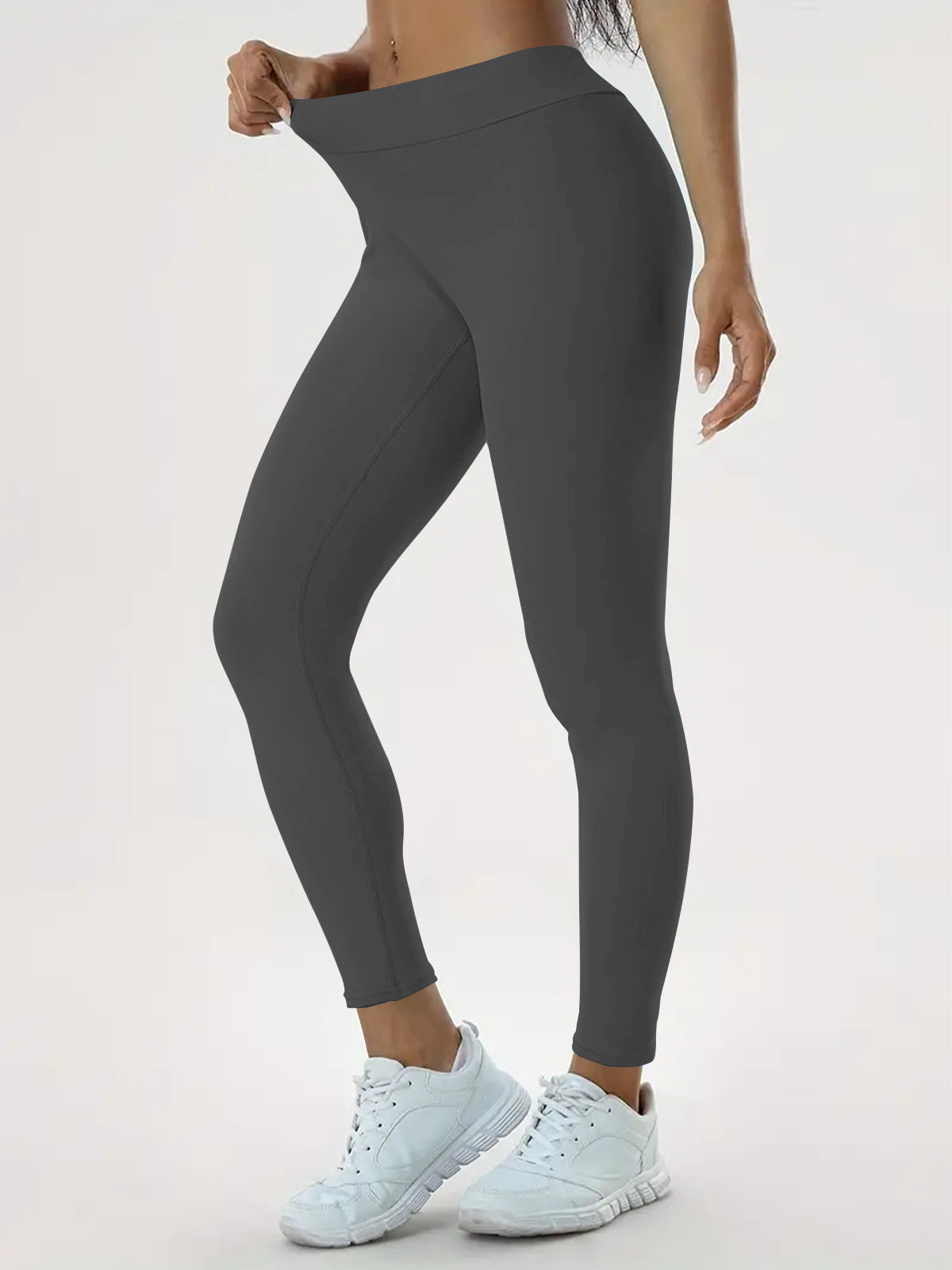 pikywiky high-waisted dark grey athletic leggings with ruched back detail worn by a model with white sneakers