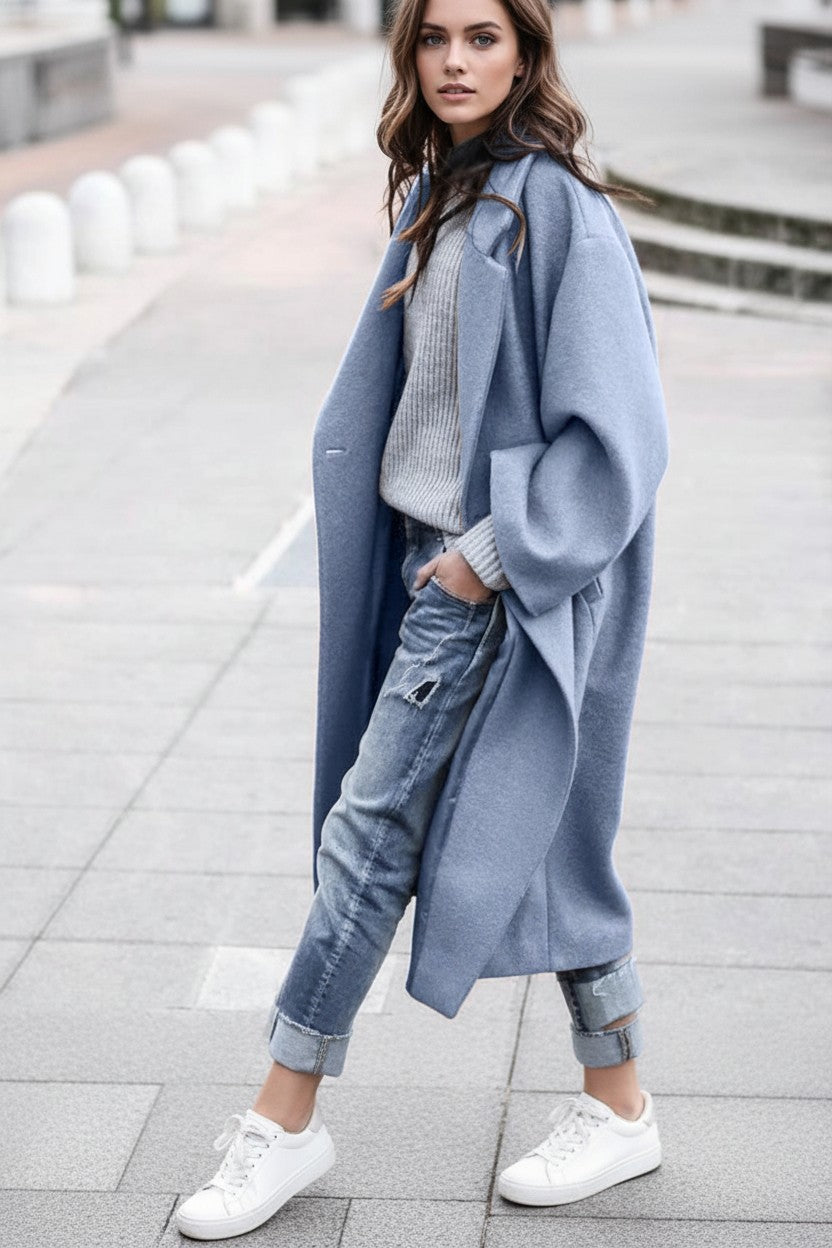 Woman wearing a Pikywiky light blue long woolen coat with jeans and white sneakers