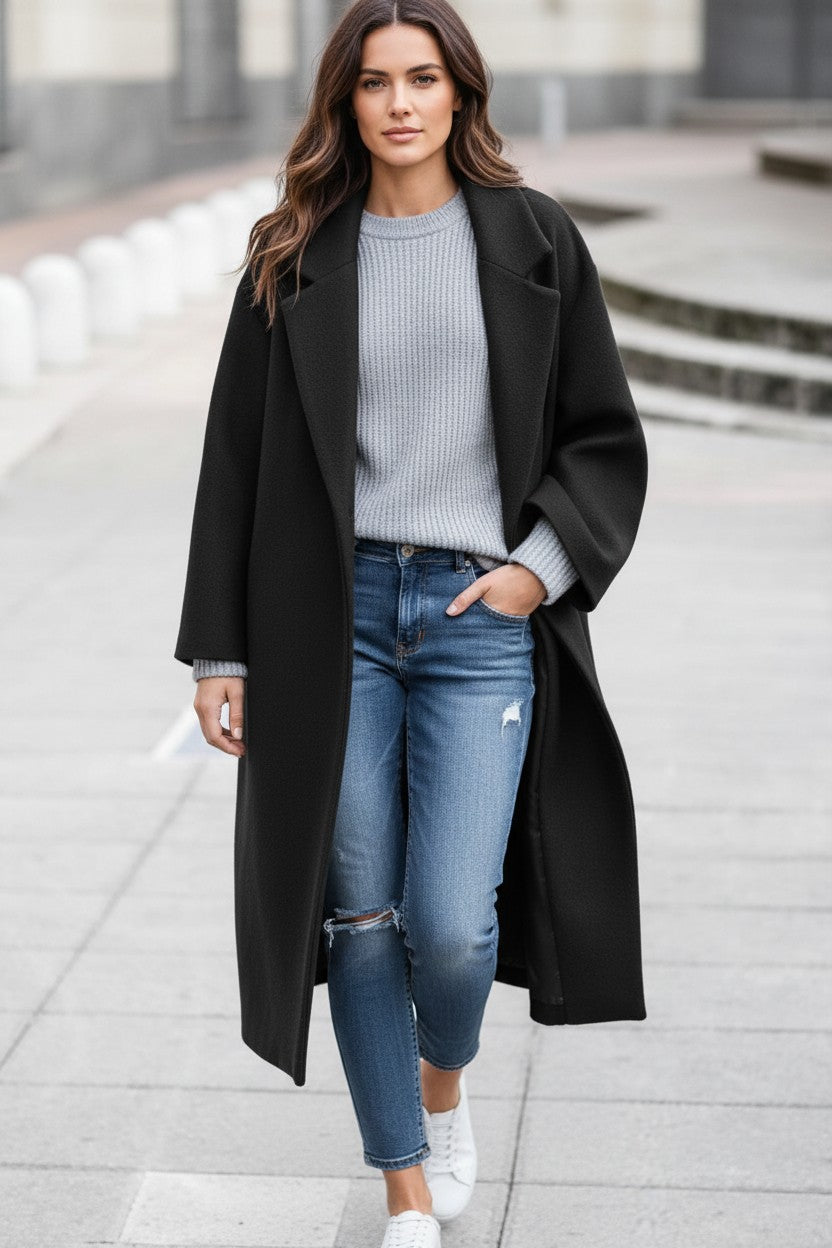 Woman wearing a Pikywiky black long woolen coat with a gray sweater and jeans