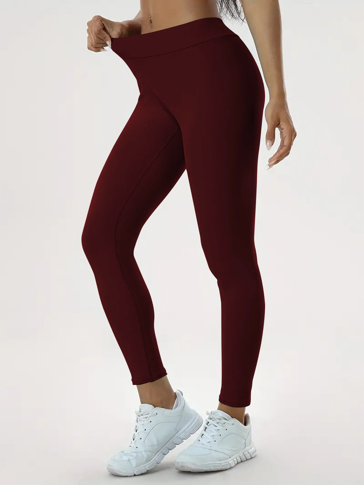 pikywiky high-waisted maroon athletic leggings with ruched back detail worn by a model for yoga and fitness training