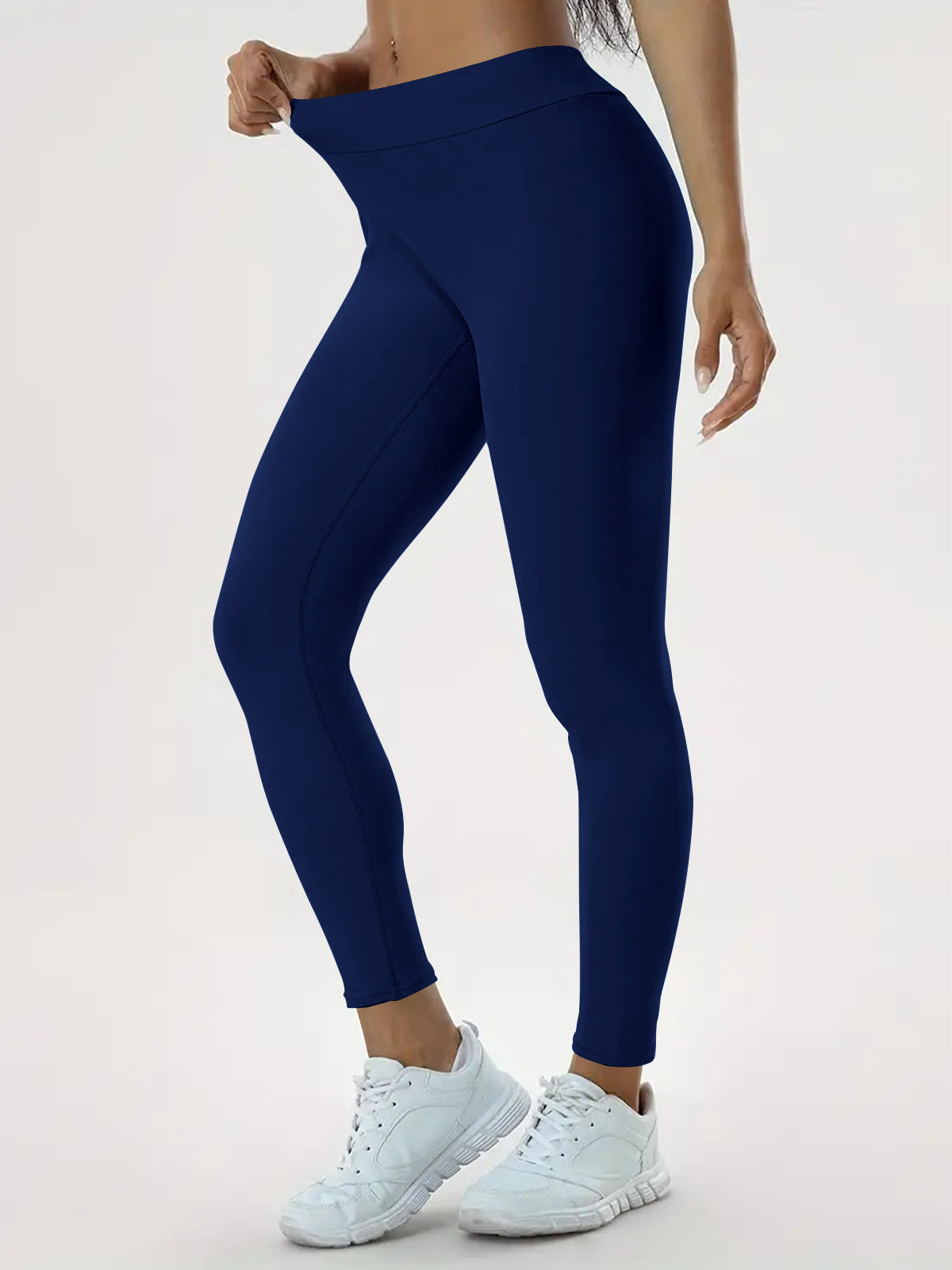 pikywiky high waisted navy blue athletic leggings with ruched back detail worn by a model with white sneakers