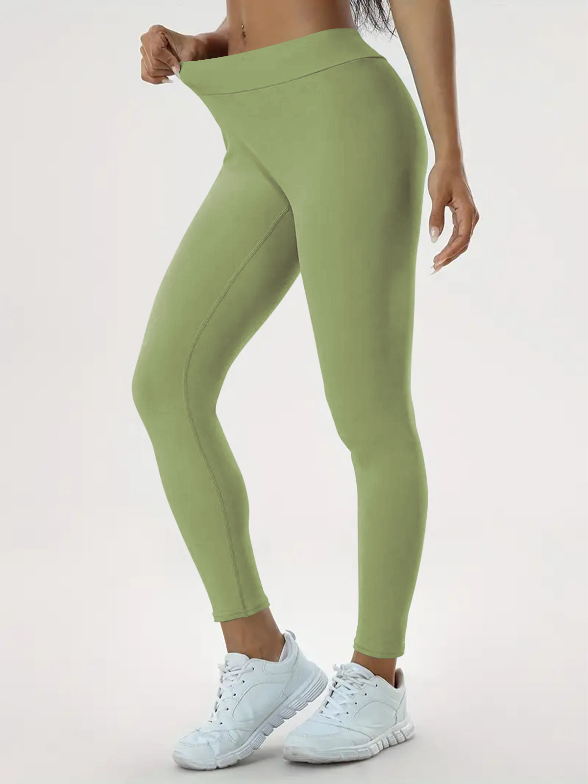 pikywiky high-waisted sage green athletic leggings with ruched back detail worn by a model with white sneakers