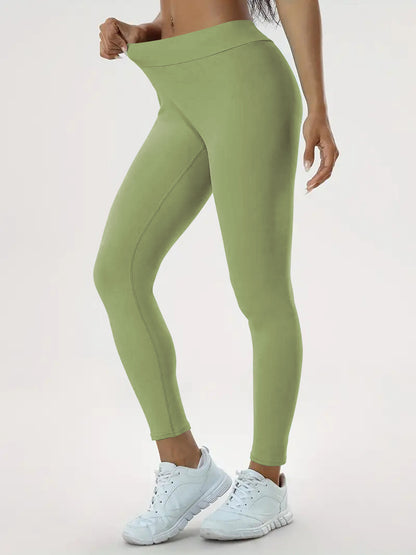 pikywiky high-waisted sage green athletic leggings with ruched back detail worn by a model with white sneakers