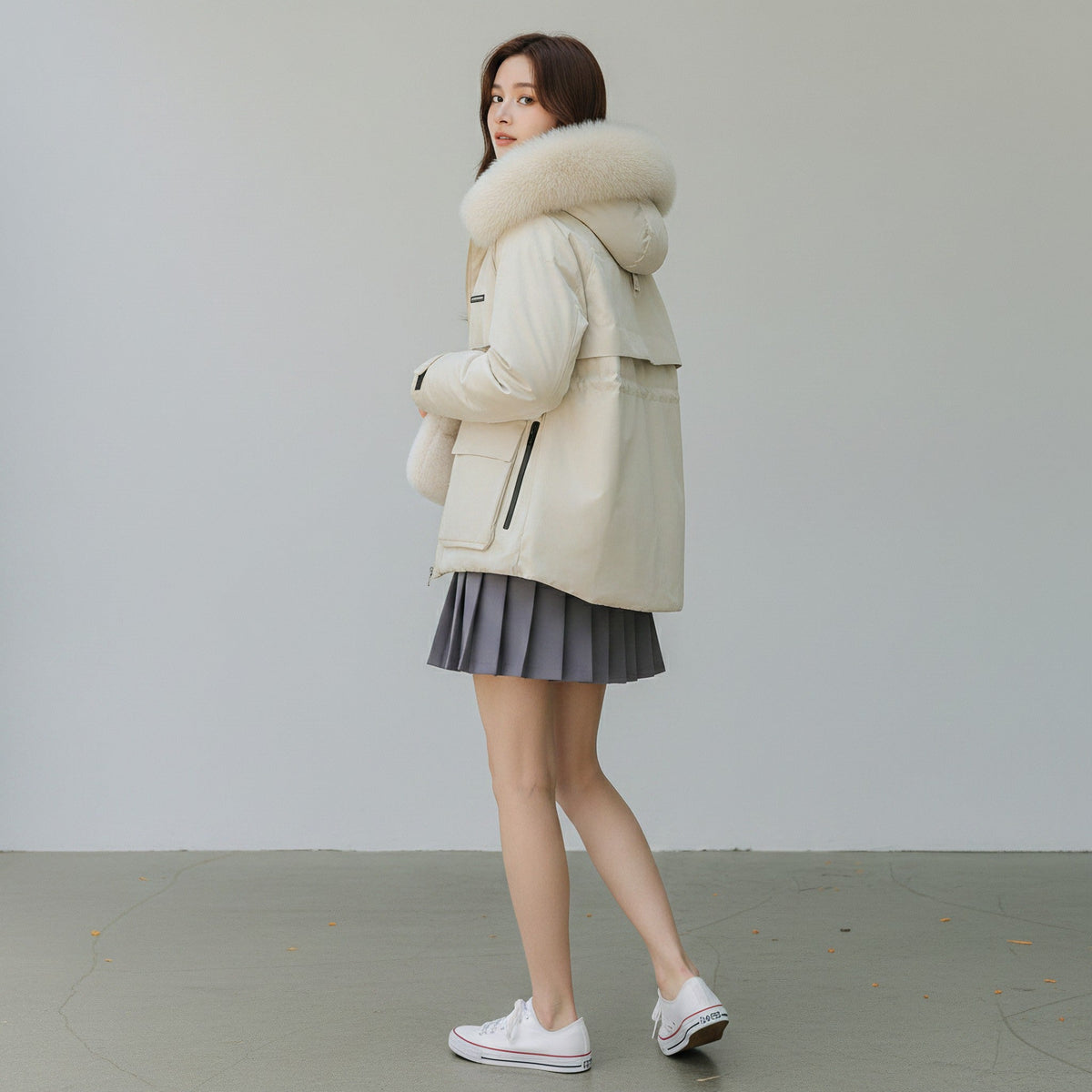 pikywiky white puffer jacket with a plush faux fur hood, worn by a woman with a grey pleated skirt and white sneakers